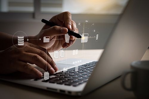 Hands holding Pen and Working at a laptop